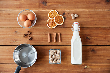 Image showing ingredients for eggnog, sugar and spices on wood