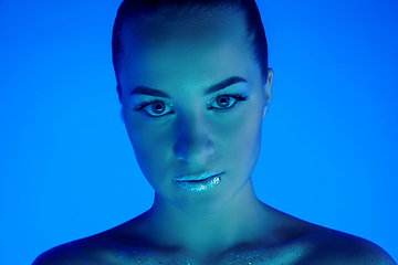 Image showing Handsome woman\'s portrait isolated on blue studio background in neon light, monochrome