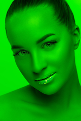 Image showing Handsome woman\'s portrait isolated on green studio background in neon light, monochrome