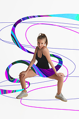 Image showing Stylish young girl\'s portrait on white studio background with bright illustrated lines of fluid neoned colors. Having fun, happy, full length