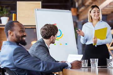 Image showing Diverse group of co-workers having casual discussion in office. Executives during friendly discussion, month reporting, creative meeting