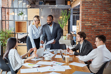 Image showing Diverse group of co-workers having casual discussion in office. Executives during friendly discussion, month reporting, creative meeting