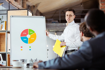 Image showing Diverse group of co-workers having casual discussion in office. Executives during friendly discussion, month reporting, creative meeting