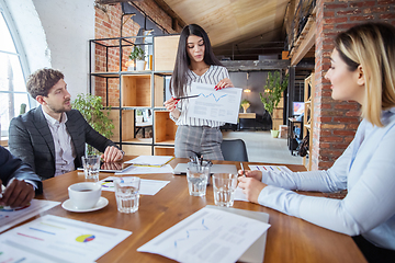 Image showing Diverse group of co-workers having casual discussion in office. Executives during friendly discussion, month reporting, creative meeting