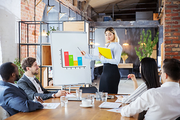 Image showing Diverse group of co-workers having casual discussion in office. Executives during friendly discussion, month reporting, creative meeting