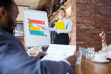 Image showing Diverse group of co-workers having casual discussion in office. Executives during friendly discussion, month reporting, creative meeting