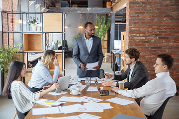 Image showing Diverse group of co-workers having casual discussion in office. Executives during friendly discussion, month reporting, creative meeting