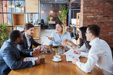 Image showing Diverse group of co-workers having casual discussion in office. Executives during friendly discussion, month reporting, creative meeting