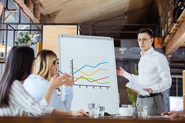 Image showing Diverse group of co-workers having casual discussion in office. Executives during friendly discussion, month reporting, creative meeting