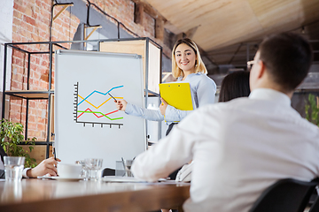 Image showing Diverse group of co-workers having casual discussion in office. Executives during friendly discussion, month reporting, creative meeting