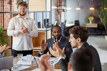 Image showing Diverse group of co-workers having casual discussion in office. Executives during friendly discussion, month reporting, creative meeting