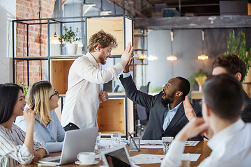 Image showing Diverse group of co-workers having casual discussion in office. Executives during friendly discussion, month reporting, creative meeting