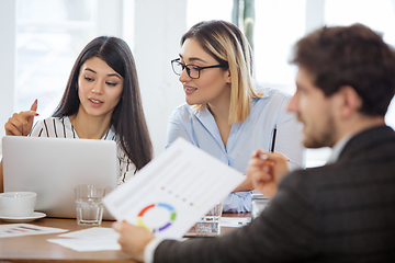 Image showing Diverse group of co-workers having casual discussion in office. Executives during friendly discussion, month reporting, creative meeting