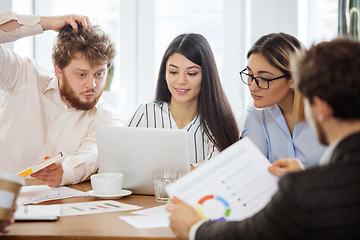 Image showing Diverse group of co-workers having casual discussion in office. Executives during friendly discussion, month reporting, creative meeting