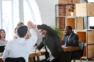 Image showing Diverse group of co-workers having casual discussion in office. Executives during friendly discussion, month reporting, creative meeting