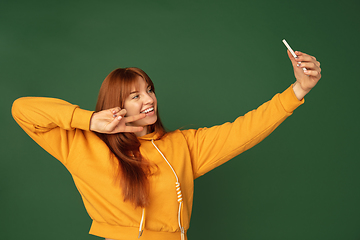 Image showing Caucasian woman\'s portrait isolated on green studio background with copyspace