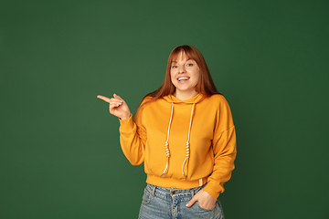 Image showing Caucasian woman\'s portrait isolated on green studio background with copyspace