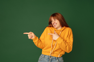 Image showing Caucasian woman\'s portrait isolated on green studio background with copyspace