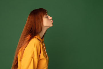 Image showing Caucasian woman\'s portrait isolated on green studio background with copyspace