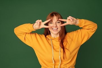 Image showing Caucasian woman\'s portrait isolated on green studio background with copyspace