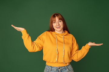 Image showing Caucasian woman\'s portrait isolated on green studio background with copyspace