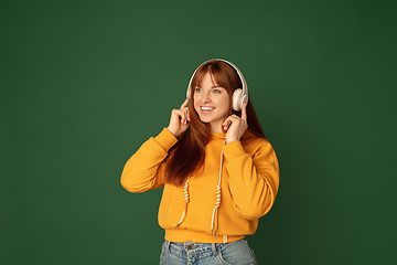 Image showing Caucasian woman\'s portrait isolated on green studio background with copyspace