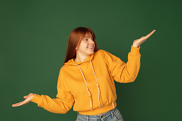 Image showing Caucasian woman\'s portrait isolated on green studio background with copyspace