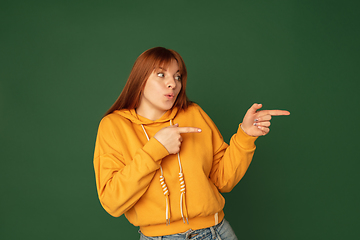 Image showing Caucasian woman\'s portrait isolated on green studio background with copyspace