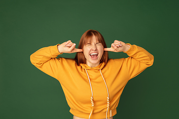 Image showing Caucasian woman\'s portrait isolated on green studio background with copyspace