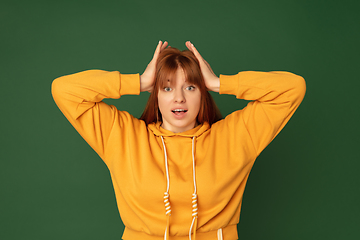 Image showing Caucasian woman\'s portrait isolated on green studio background with copyspace