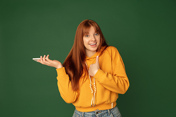 Image showing Caucasian woman\'s portrait isolated on green studio background with copyspace