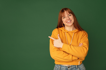 Image showing Caucasian woman\'s portrait isolated on green studio background with copyspace