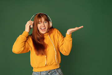 Image showing Caucasian woman\'s portrait isolated on green studio background with copyspace