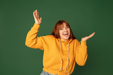 Image showing Caucasian woman\'s portrait isolated on green studio background with copyspace