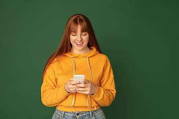 Image showing Caucasian woman\'s portrait isolated on green studio background with copyspace