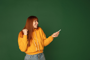 Image showing Caucasian woman\'s portrait isolated on green studio background with copyspace