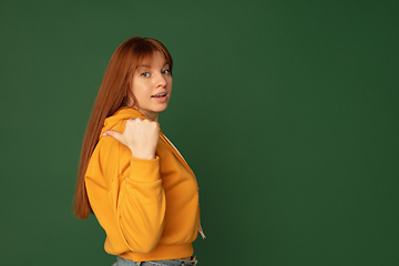 Image showing Caucasian woman\'s portrait isolated on green studio background with copyspace