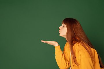 Image showing Caucasian woman\'s portrait isolated on green studio background with copyspace