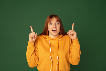 Image showing Caucasian woman\'s portrait isolated on green studio background with copyspace