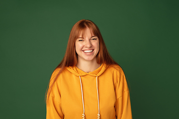 Image showing Caucasian woman\'s portrait isolated on green studio background with copyspace