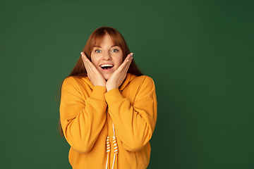 Image showing Caucasian woman\'s portrait isolated on green studio background with copyspace