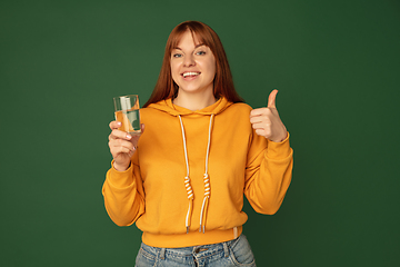 Image showing Caucasian woman\'s portrait isolated on green studio background with copyspace