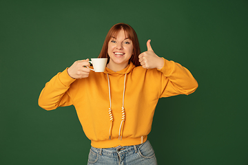 Image showing Caucasian woman\'s portrait isolated on green studio background with copyspace