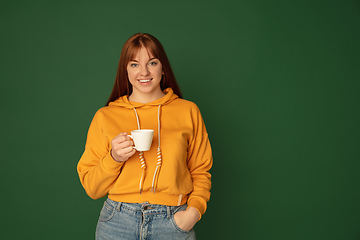 Image showing Caucasian woman\'s portrait isolated on green studio background with copyspace