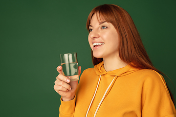 Image showing Caucasian woman\'s portrait isolated on green studio background with copyspace