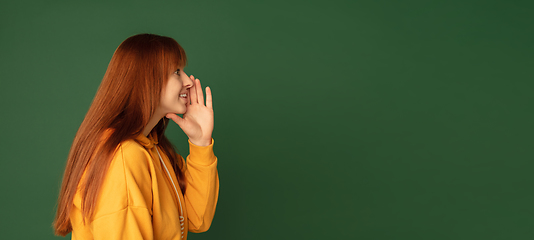 Image showing Caucasian woman\'s portrait isolated on green studio background with copyspace, horizontal flyer