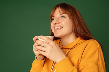 Image showing Caucasian woman\'s portrait isolated on green studio background with copyspace