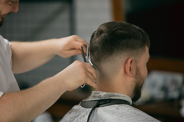 Image showing Close up master barber, stylist does the hairstyle to guy, young man. Professional occupation, male beauty concept