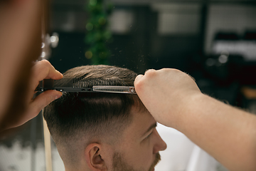 Image showing Close up master barber, stylist does the hairstyle to guy, young man. Professional occupation, male beauty concept