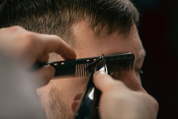 Image showing Close up of client of master barber, stylist during getting care of hairstyle. Professional occupation, male beauty concept